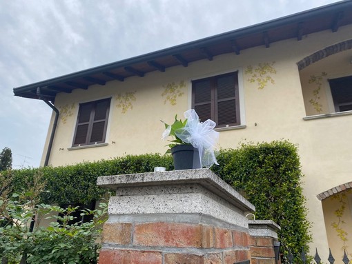 Un vaso di fiori e un lumino sull'entrata di casa in omaggio alle vittime