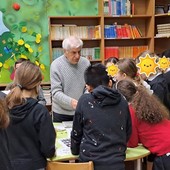 Una bellissima immagine di Ermanno Bazzani con i bimbi chini sui francobolli con lui