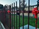 Fiocchi rossi sul cancello della scuola Toscanini di Legnano