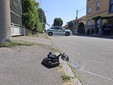 Alcuni pezzi della Vespa incidentata e i segni dei rilievi della Polizia Locale