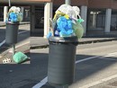 Cestini con sacchi di immondizia: un'immagine diffusa in città (nel riquadro evidenziata anche la presenza di un sacco sotto)