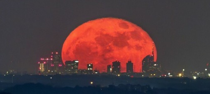 La foto della Luna rossa che attraversa lo skyline di Milano è nata sulle alture del lago Maggiore